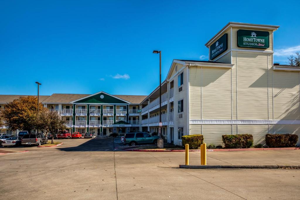 a large hotel with a parking lot in front of it at HomeTowne Studios by Red Roof Austin in Cedar Park