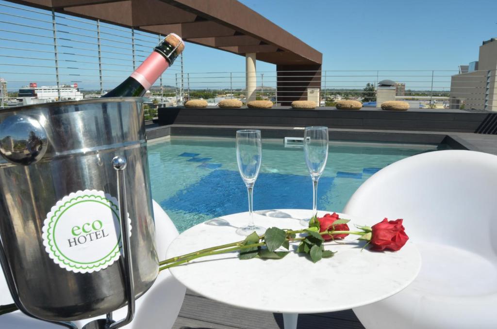 a table with two glasses and a bottle of wine at Ecohotel Talca in Talca