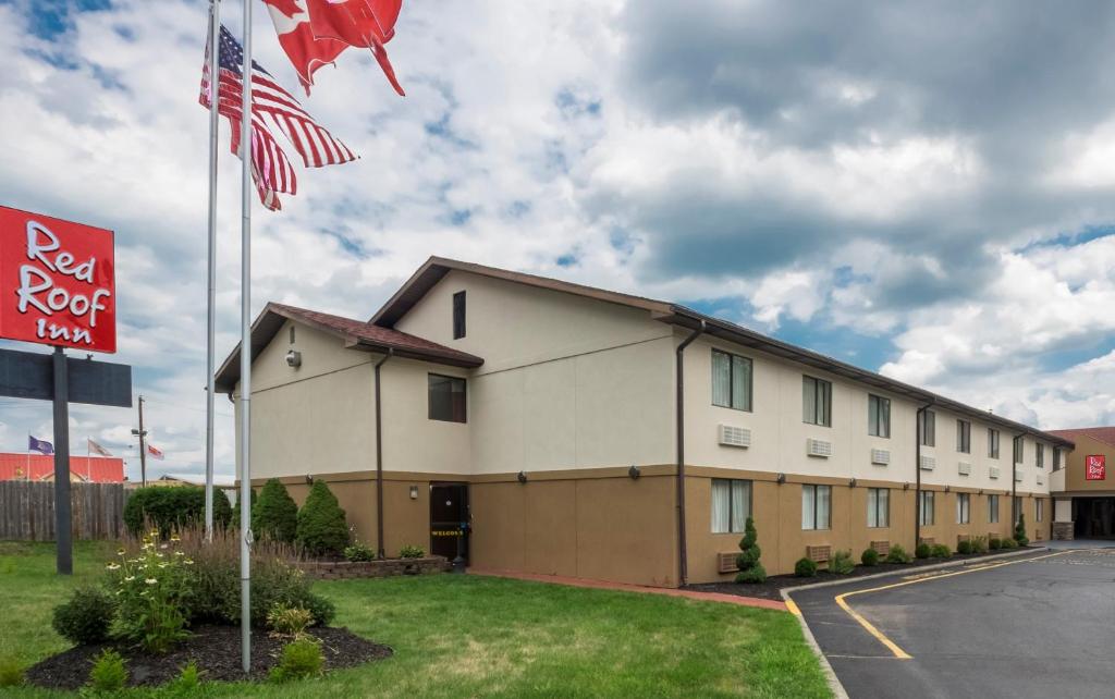 un edificio con una bandera americana delante de él en Red Roof Inn Binghamton North en Binghamton