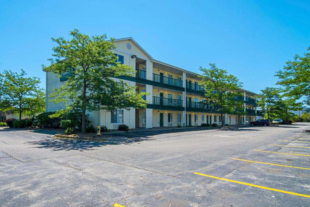 een lege parkeerplaats voor een gebouw bij HomeTowne Studios by Red Roof Chicago - Waukegan in Waukegan