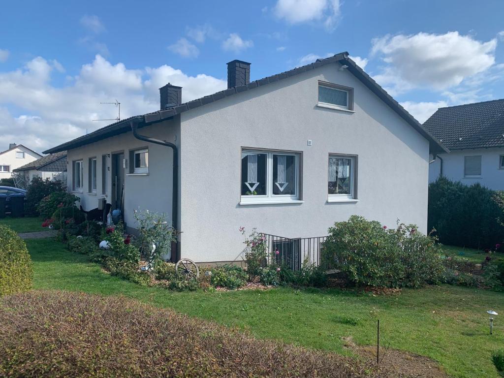 a white house with a yard at Sauerlandblick - Appartement & FeWo Wickede in Wickede (Ruhr)