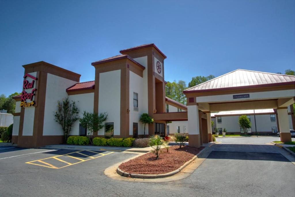 a hotel with a parking lot in front of it at Red Roof Inn PLUS+ Henderson in Henderson