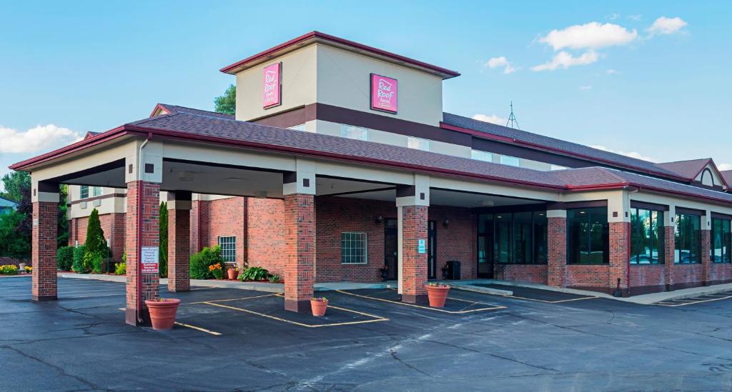 un edificio con un estacionamiento delante de él en Red Roof Inn & Suites Lake Orion / Auburn Hills, en Lake Orion