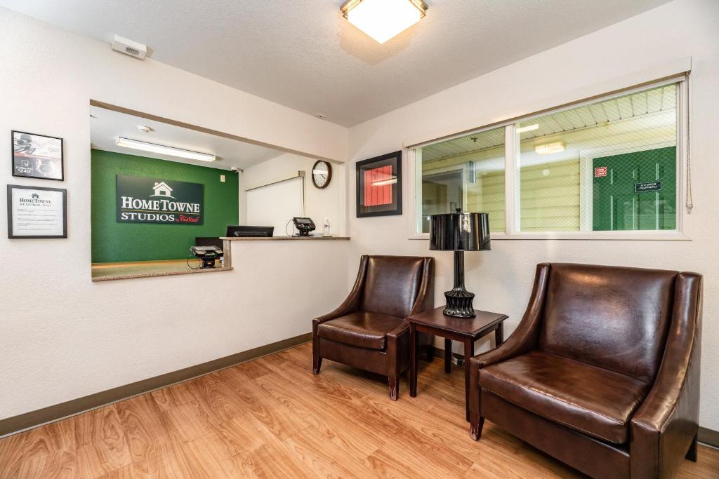 a waiting room with two chairs and a table at HomeTowne Studios by Red Roof Fresno - West in Fresno