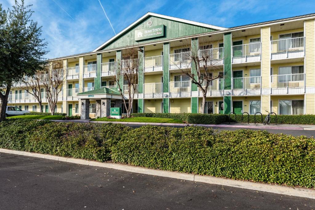 a large building with a street in front of it at HomeTowne Studios by Red Roof Fresno - West in Fresno