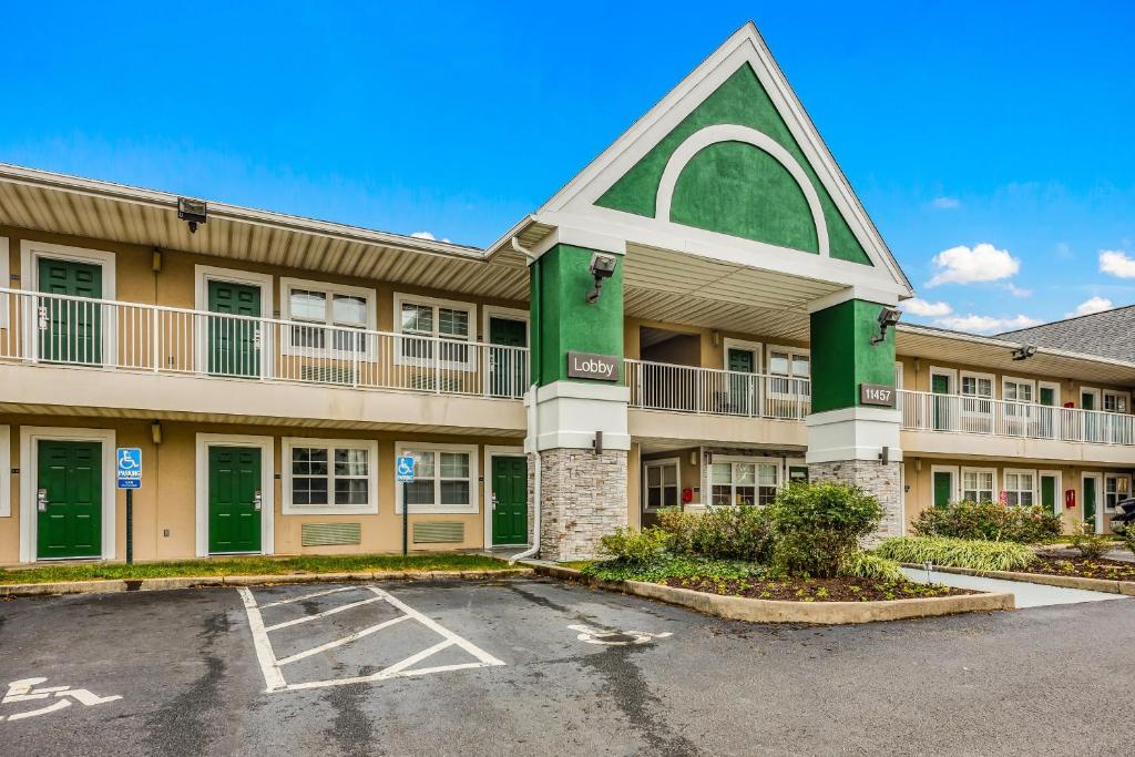 a large apartment building with a parking lot at HomeTowne by Red Roof Studios Cincinnati - Sharonville in Sharonville
