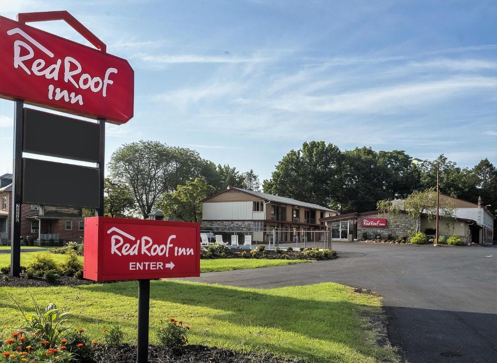 una señal de la posada de roca roja frente a un edificio en Red Roof Inn Lancaster Strasburg, en Lancaster