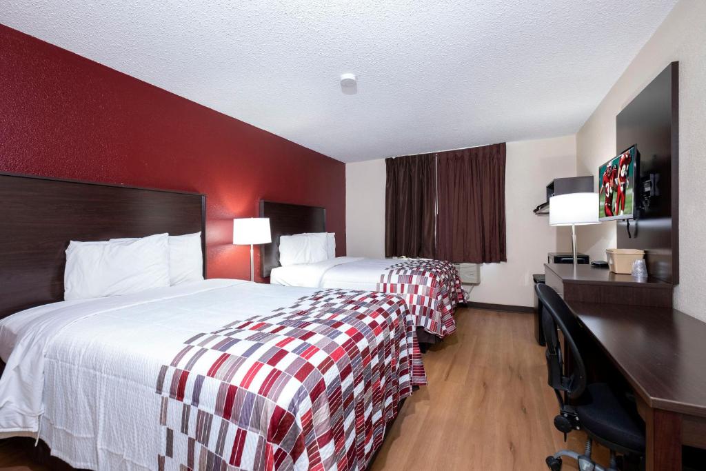 a hotel room with two beds and a red wall at Red Roof Inn Norfolk - Portsmouth in Portsmouth