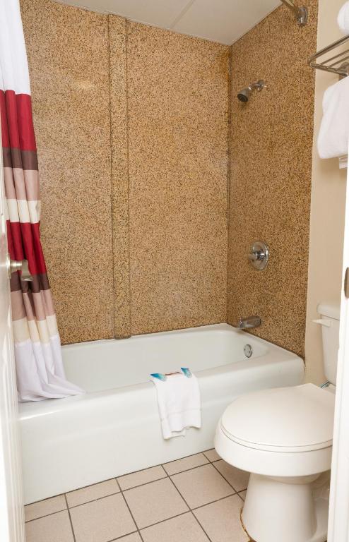 a bathroom with a white tub and a toilet at Red Roof Inn & Suites Pigeon Forge Parkway in Pigeon Forge