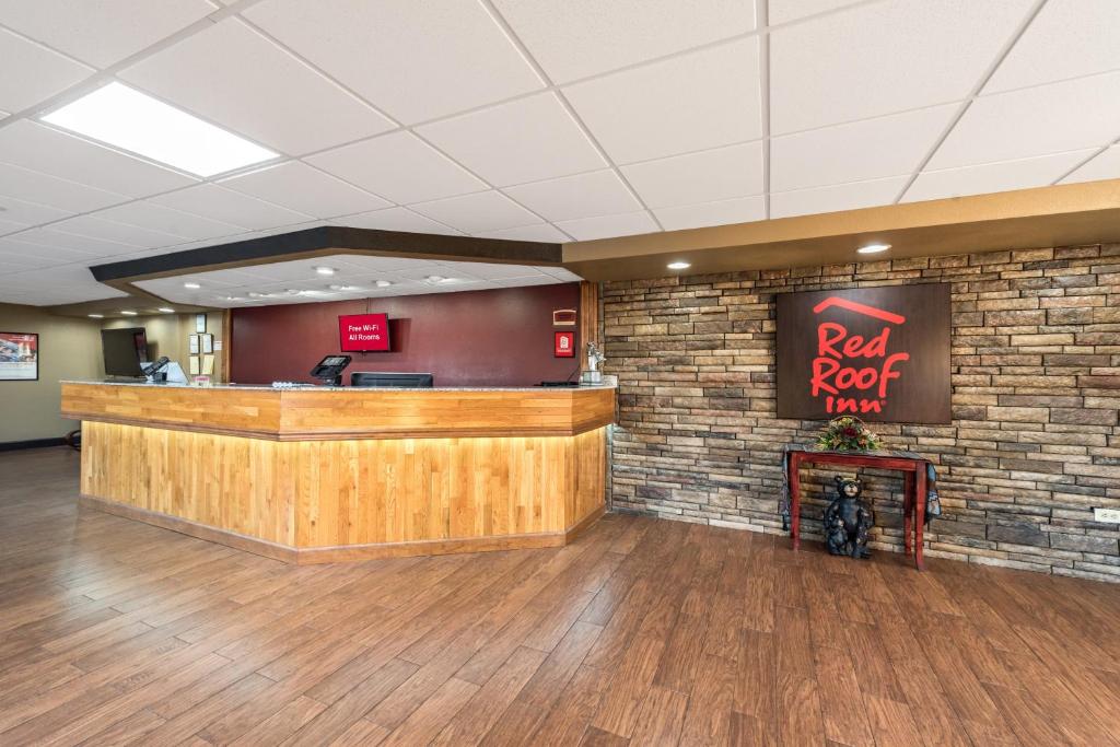 a restaurant lobby with a red roof inn sign on a brick wall at Red Roof Inn & Suites Pigeon Forge Parkway in Pigeon Forge