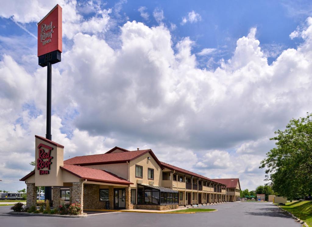 a building with a sign in the middle of a street at Red Roof Inn Indianapolis - Greenwood in Greenwood