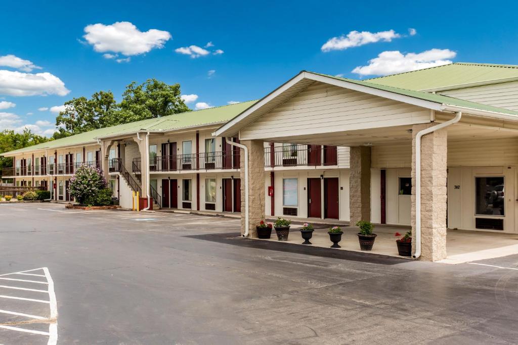 a row of buildings with potted plants in a parking lot at Red Roof Inn Monteagle - I-24 in Monteagle