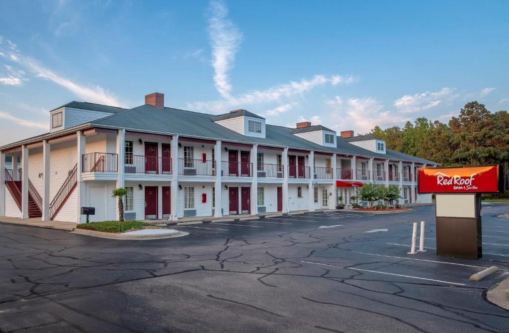 a row of buildings in a parking lot at Red Roof Inn & Suites Wilson in Wilson