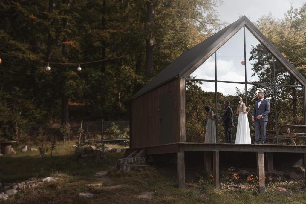uma noiva e um noivo numa casa de vidro em Szklana Stodoła em Przywidz