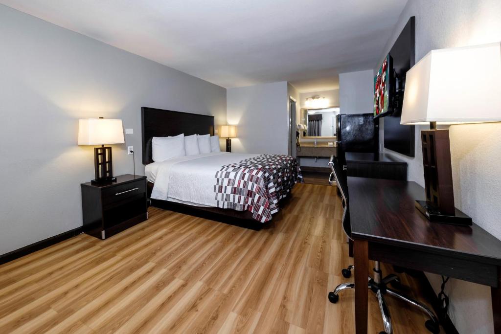 a hotel room with a bed and a desk at Red Roof Inn Arlington - Entertainment District in Arlington