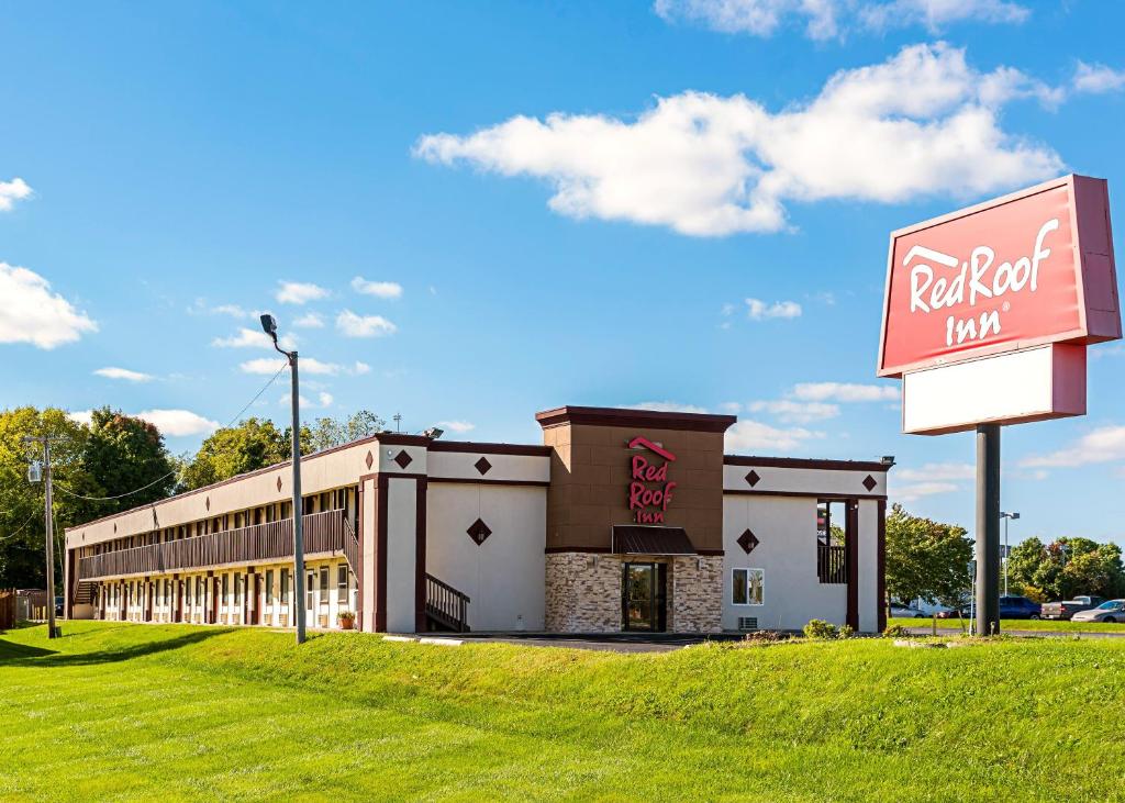 un edificio con una señal delante de él en Red Roof Inn Anderson, IN, en Anderson