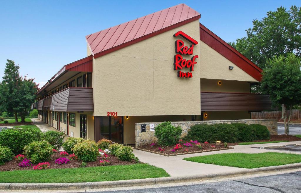 un panneau de roche rouge sur le côté d'un bâtiment dans l'établissement Red Roof Inn Greensboro Coliseum, à Greensboro