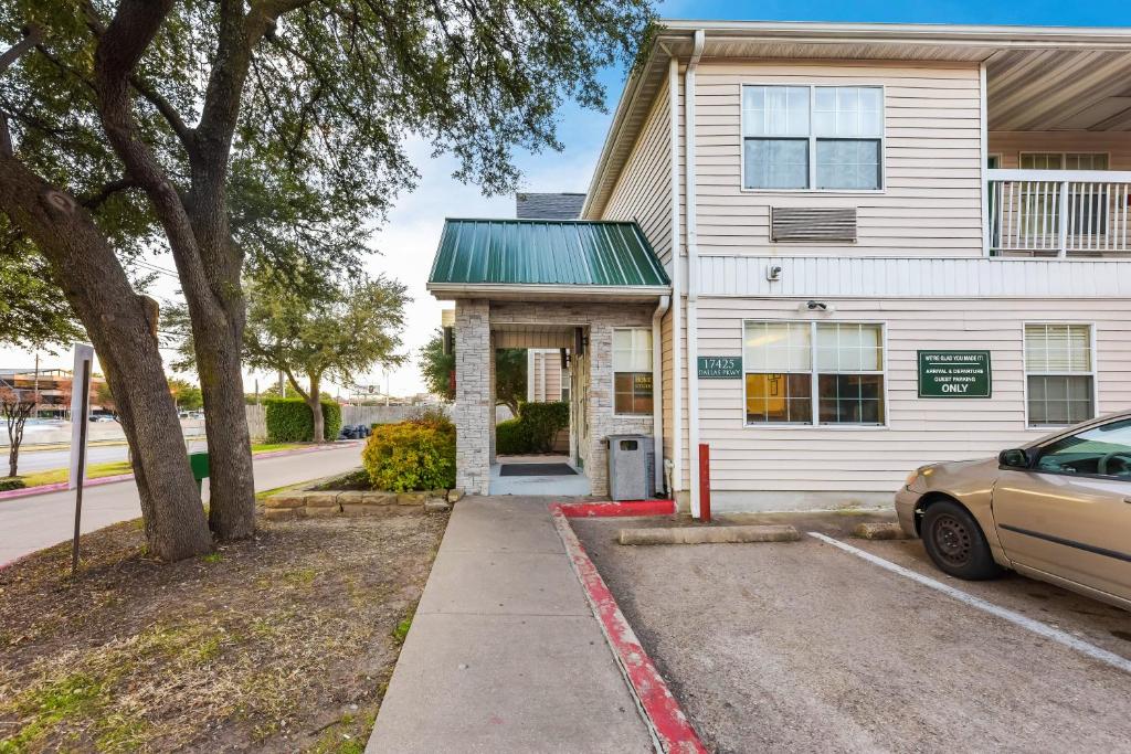 ein weißes Haus mit einem davor geparkt in der Unterkunft HomeTowne Studios by Red Roof Dallas - North Addison - Tollway in Addison