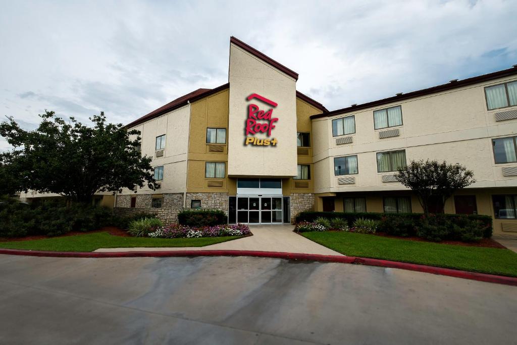 a hotel with a sign on the side of a building at Red Roof Inn PLUS+ Houston - Energy Corridor in Houston