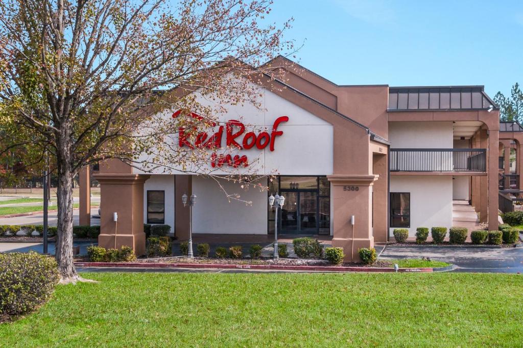 a restaurant with a red sign on the side of a building at Red Roof Inn Texarkana in Texarkana