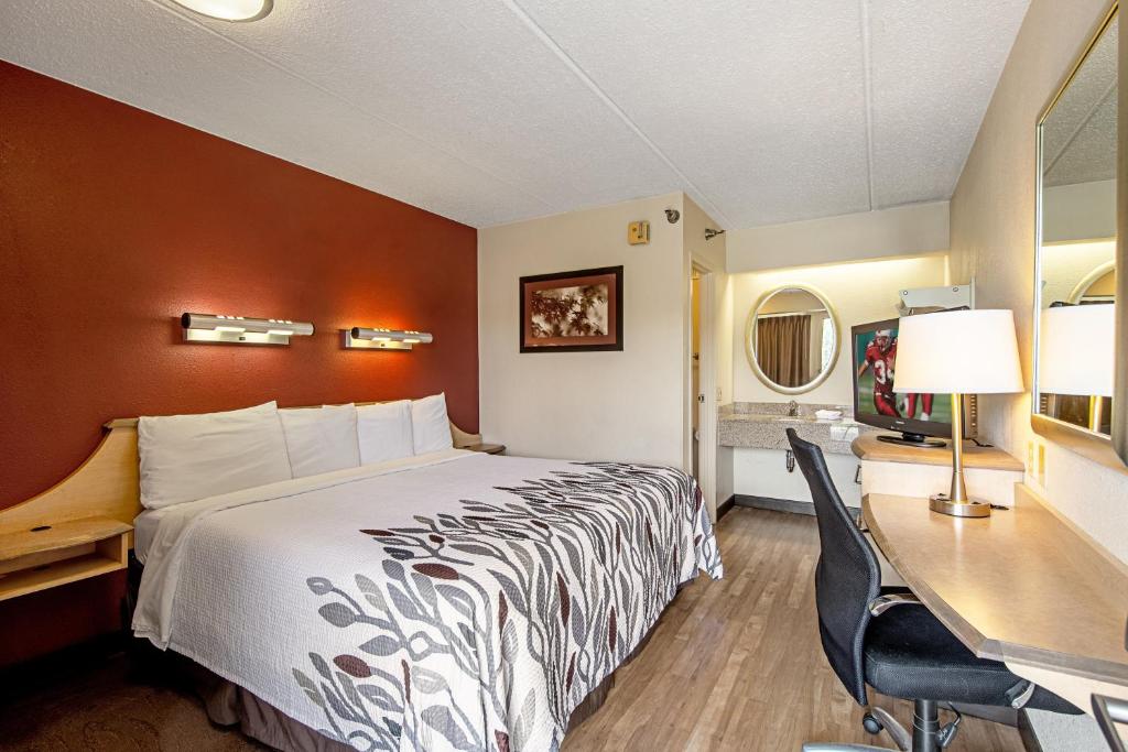 a hotel room with a bed and a desk at Red Roof Inn Johnson City in Johnson City
