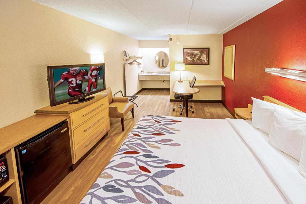 a hotel room with a bed and a flat screen tv at Red Roof Inn Johnson City in Johnson City