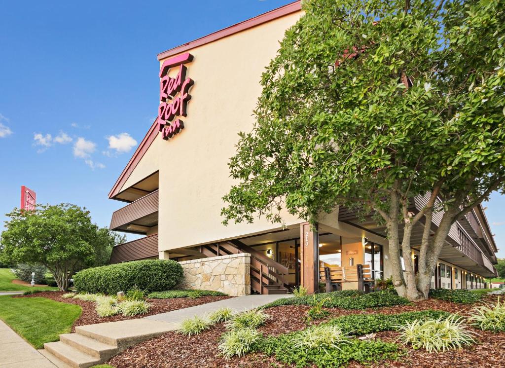 a building with a tree in front of it at Red Roof Inn Johnson City in Johnson City