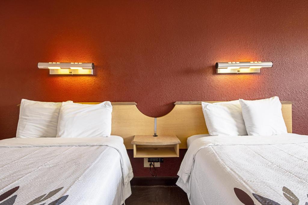 two beds in a hotel room with white sheets at Red Roof Inn Johnson City in Johnson City