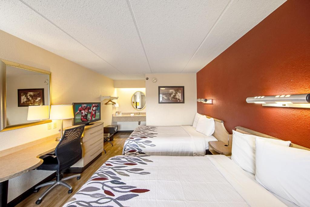 a hotel room with two beds and a desk at Red Roof Inn Johnson City in Johnson City