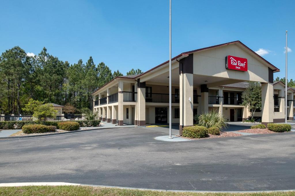 a hotel with a sign on the front of a parking lot at Red Roof Inn Gulf Shores in Gulf Shores