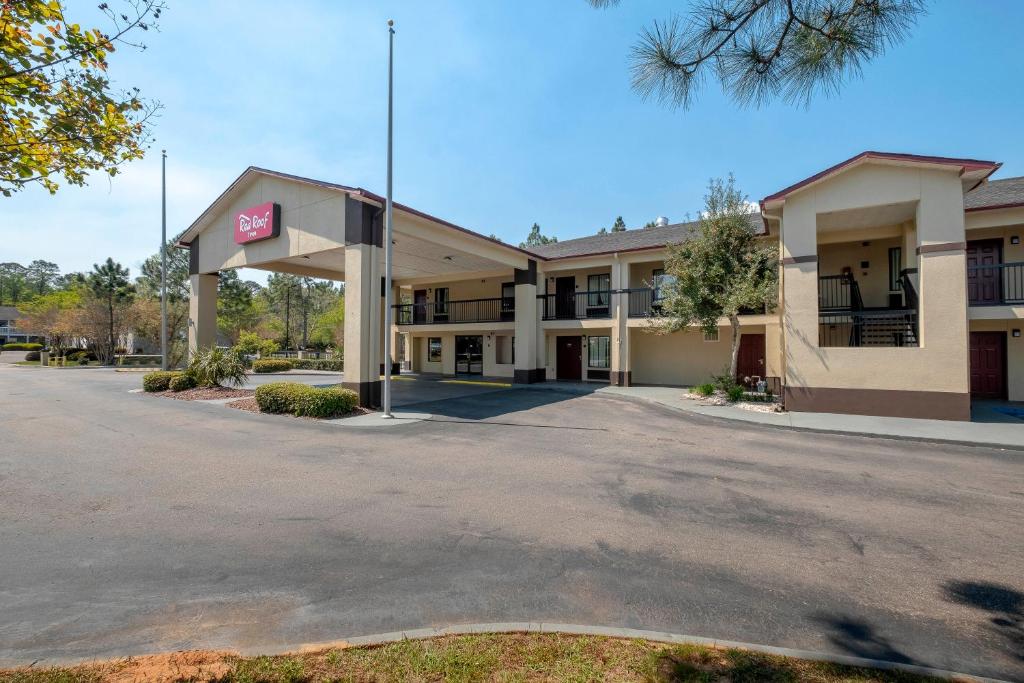 um hotel com um parque de estacionamento em frente em Red Roof Inn Gulf Shores em Gulf Shores