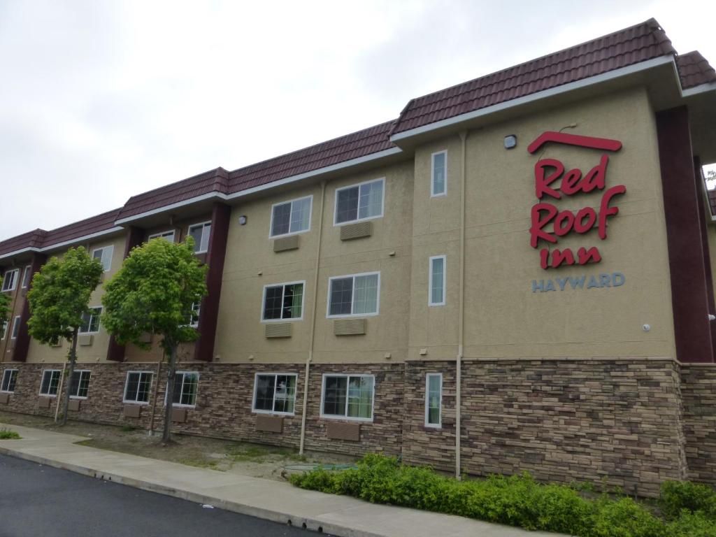 un edificio con una posada de roca roja. en Red Roof Inn Hayward, en Hayward