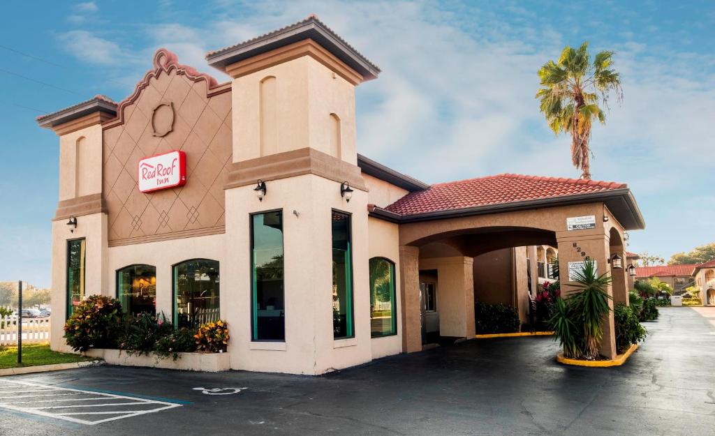 uma loja em frente a um centro comercial com uma palmeira em Red Roof Inn Orlando South - Florida Mall em Orlando