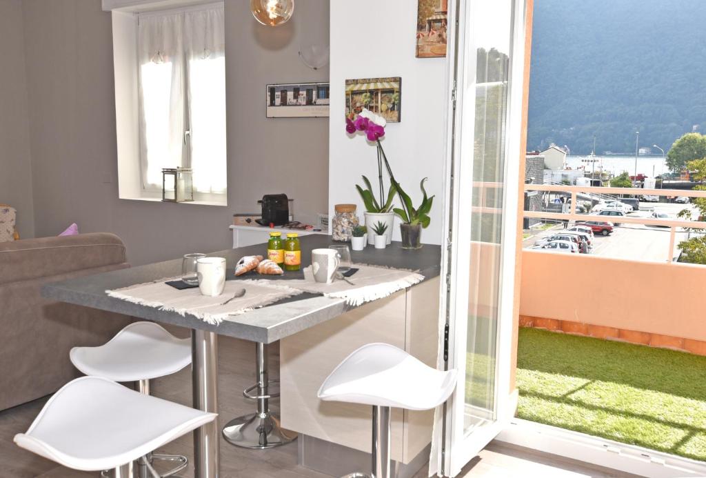 a kitchen with a table and chairs and a balcony at LE PETIT BONHEUR in Como
