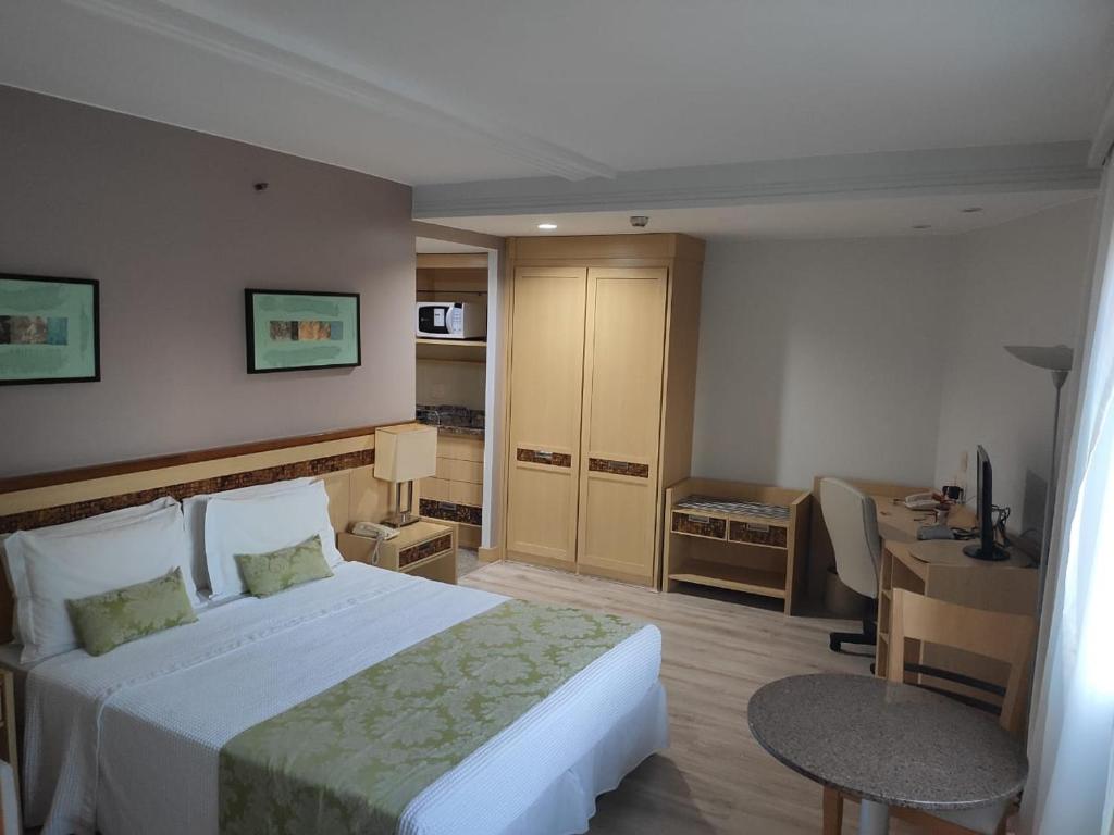 a hotel room with a large bed and a desk at Flat - Esplanada dos Ministérios - Centro de Brasília in Brasilia