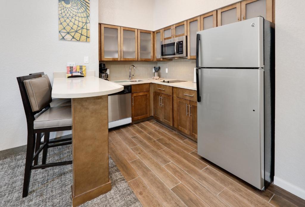 a kitchen with a white refrigerator and a table at Staybridge Suites - San Antonio - Schertz, an IHG Hotel in Schertz