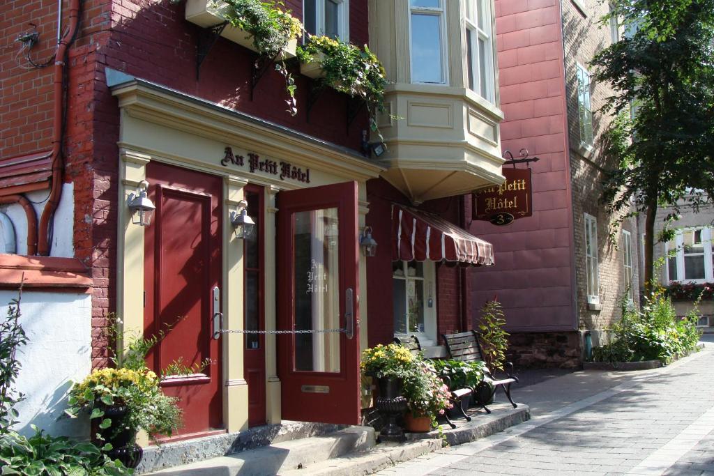 un bâtiment avec une porte rouge dans une rue dans l'établissement Au Petit Hôtel, à Québec