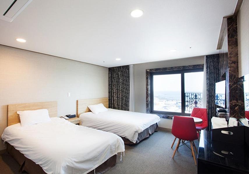 Postel nebo postele na pokoji v ubytování Dream Jeju Hotel