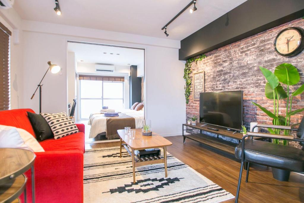 a living room with a red couch and a brick wall at Shibuya Park Residence Yoyogi Park in Tokyo