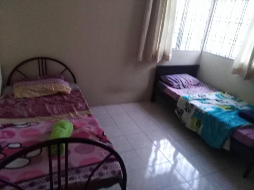 a bedroom with two beds and a window at Dorm Melati Pak Abu in Kuala Lumpur