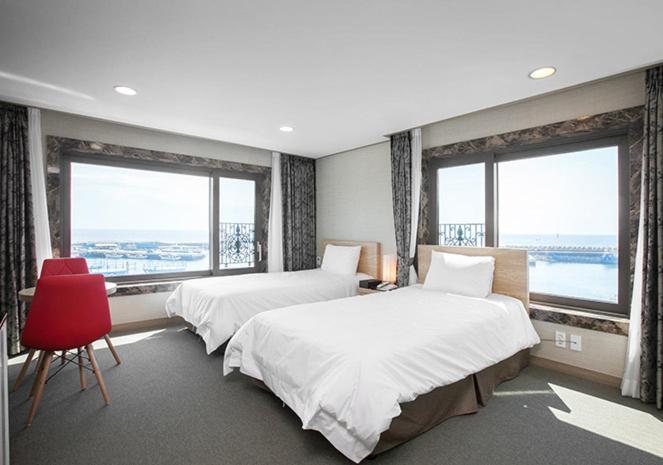 Postel nebo postele na pokoji v ubytování Dream Jeju Hotel