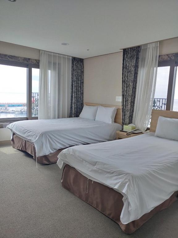 Postel nebo postele na pokoji v ubytování Dream Jeju Hotel