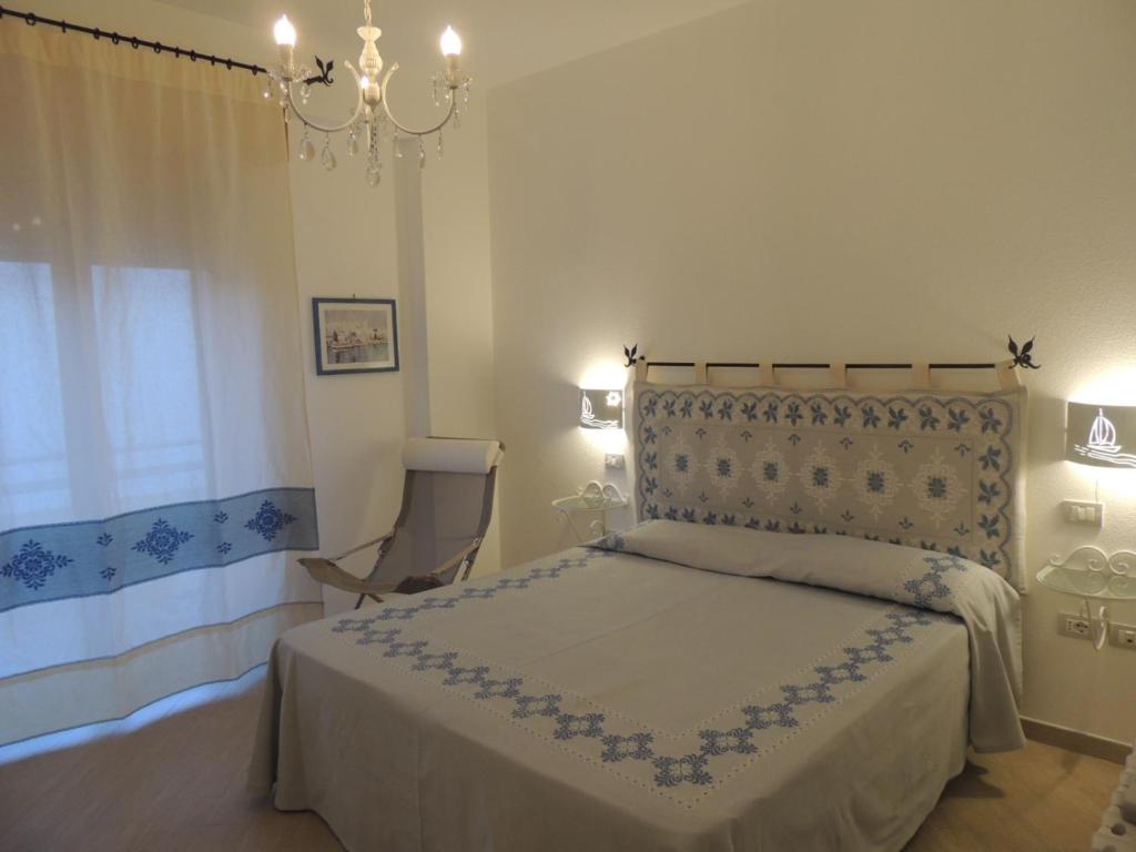 1 dormitorio con cama y lámpara de araña en Camera con Vista, en Oristano