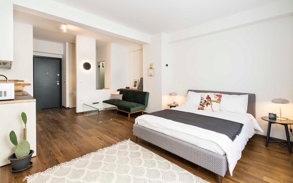 een slaapkamer met een groot bed en een groene stoel bij Athens' Best Location- Stunning & Spacious Studio in Athene