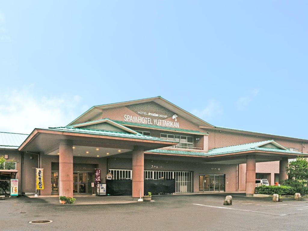a building with a sign on the front of it at SPA HOTEL YUTTARIKAN in Satsumasendai