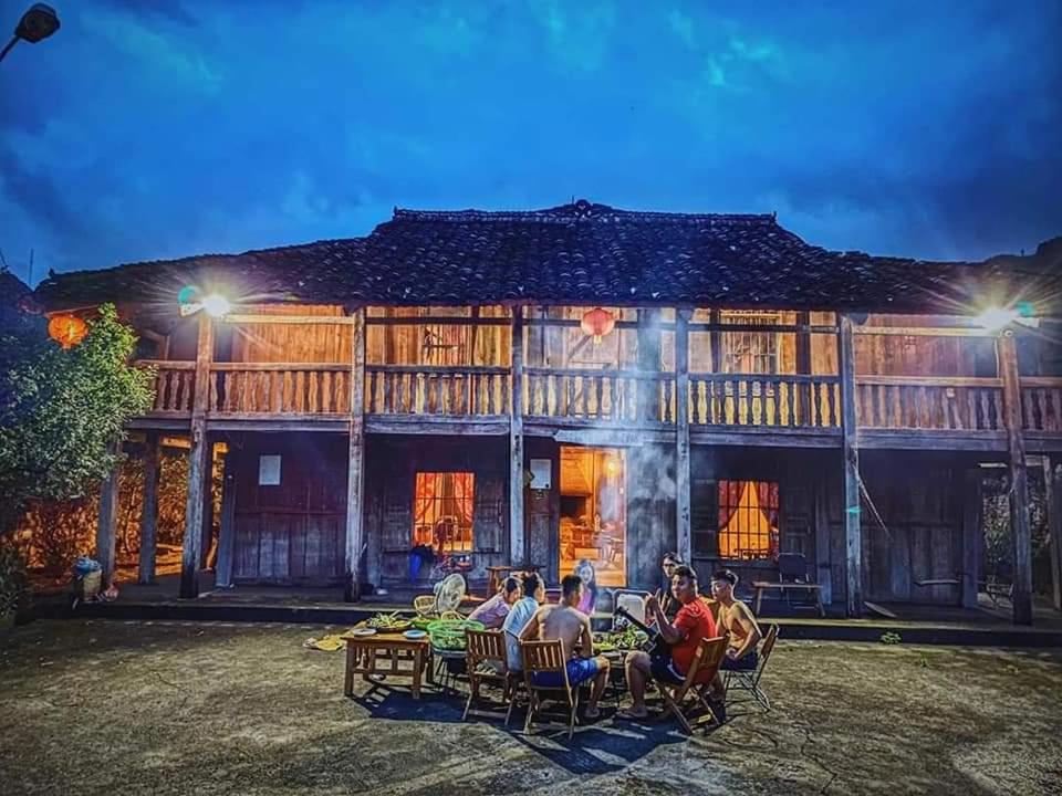 a group of people sitting at tables in front of a building at Lo Lo Homestay & Cafe Meo Vac in Mèo Vạc