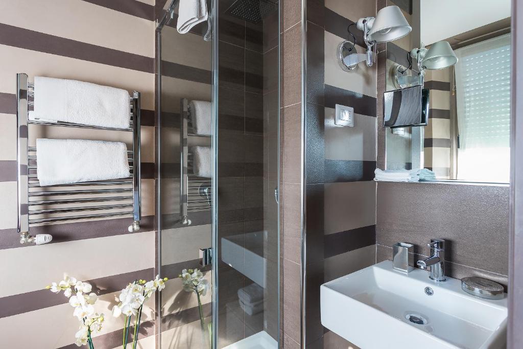 łazienka z umywalką i przeszkloną kabiną prysznicową w obiekcie Pattini Guest House w Mediolanie
