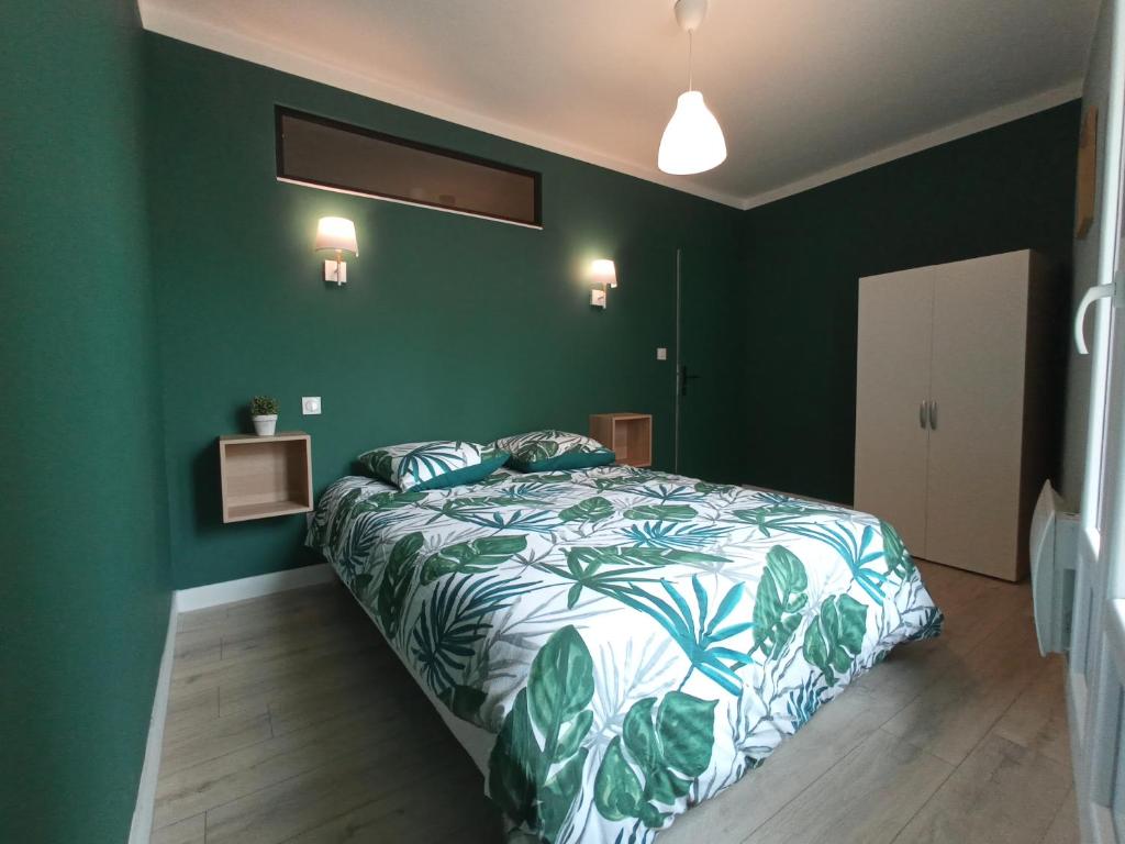 ein Schlafzimmer mit einem Bett mit einer grünen Wand in der Unterkunft Appartements Aux Portes d'Alès - Centre Ville in Alès