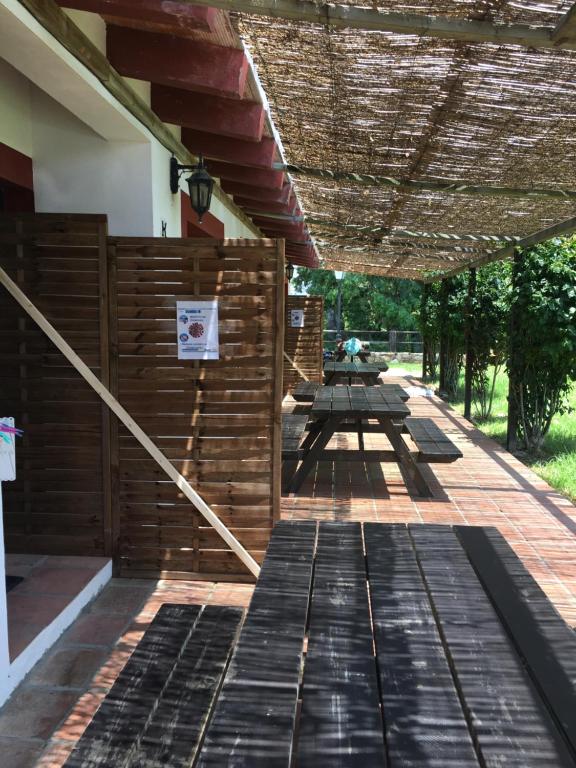 a patio with a wooden fence and picnic tables at Molino El Mastral in Tarifa