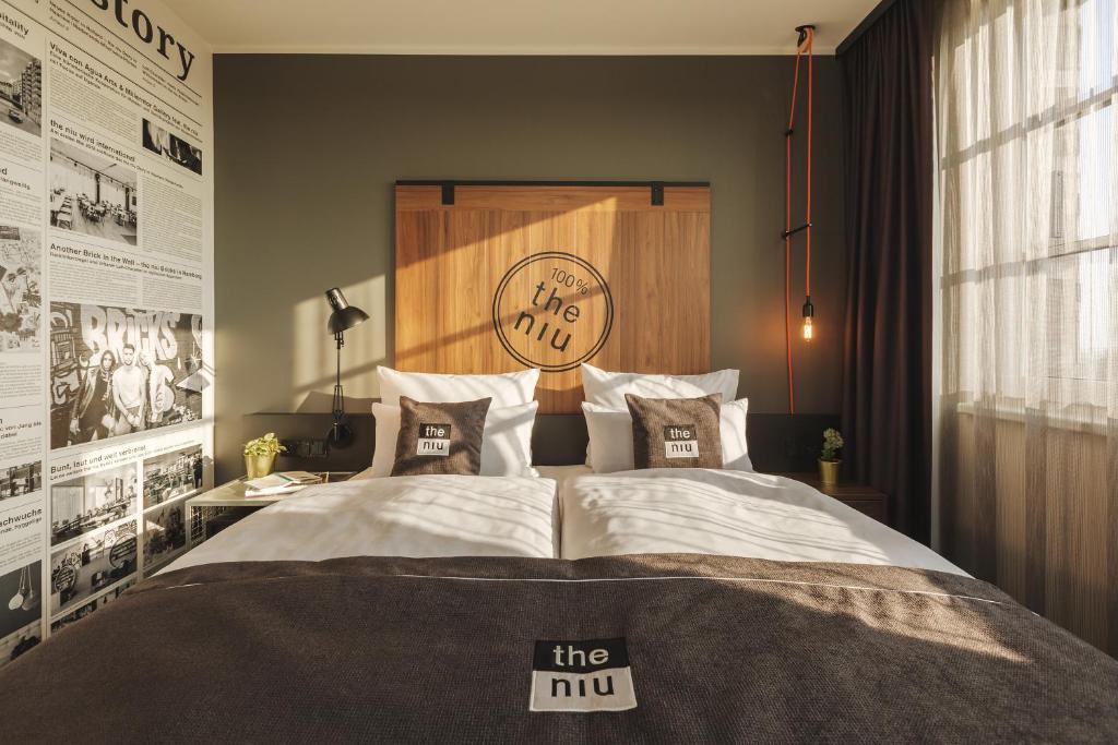 a bedroom with a large bed with a clock on the wall at the niu Bricks in Hamburg